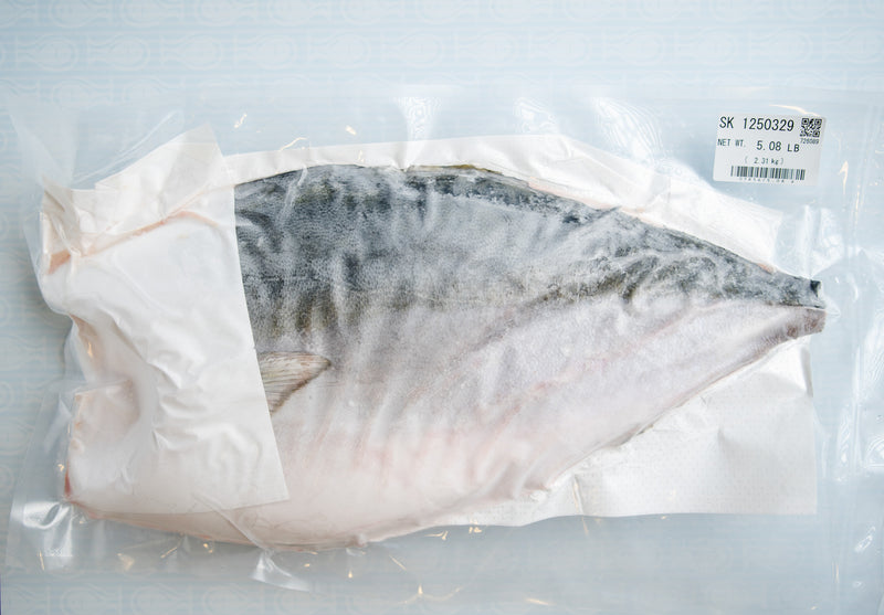 Sliced pink tuna on a white plate with a radish, against a blurred green background